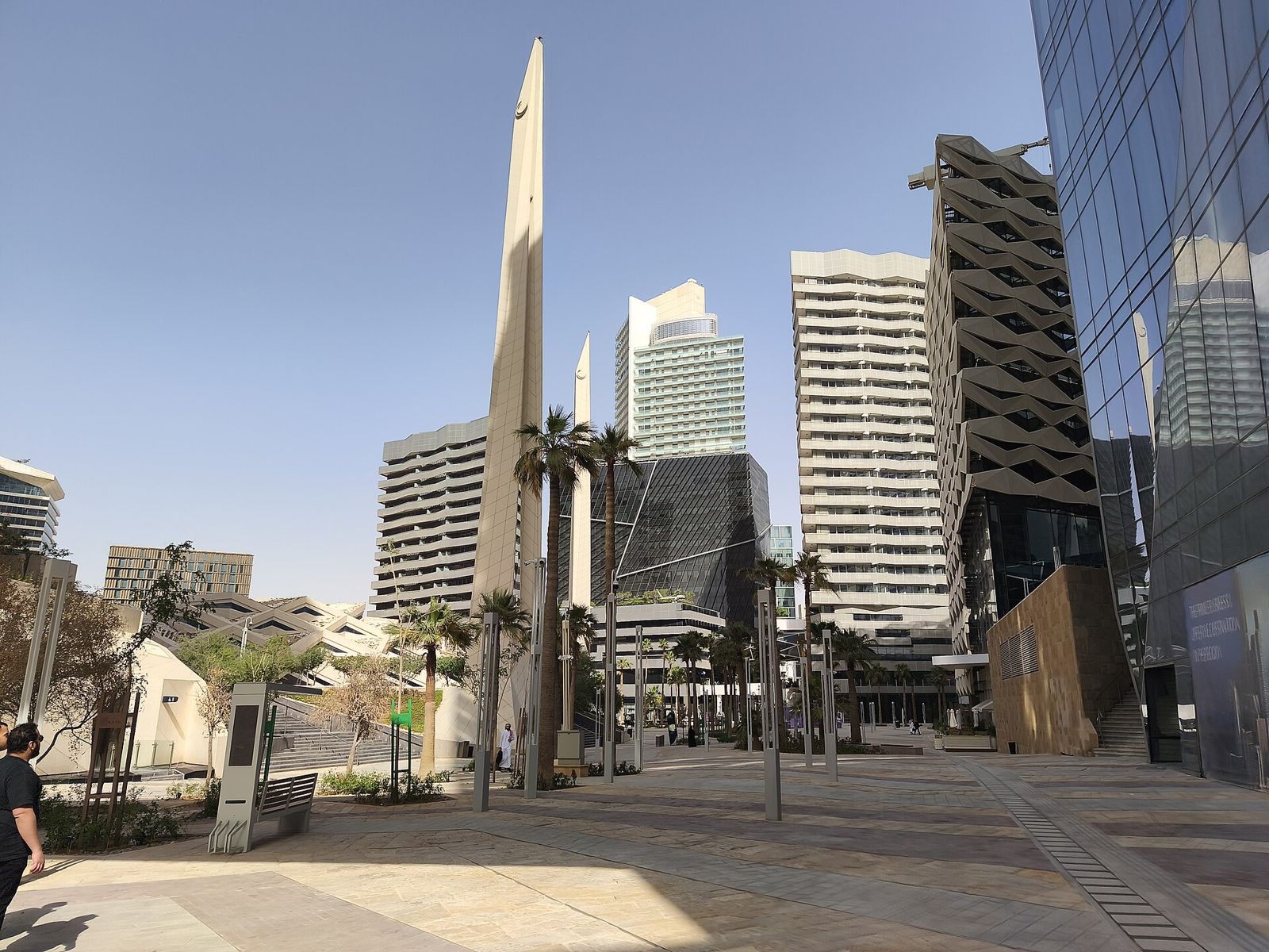 KAFD wadi plaza with palms and obelisk sculpture