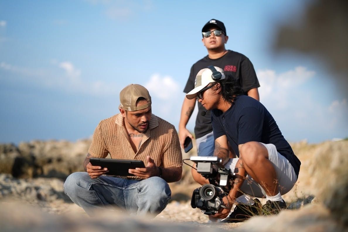 Crew members with a tablet and a camera on the rocks