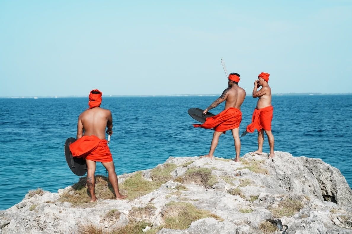 Warriors with shields on a coral rock above the sea