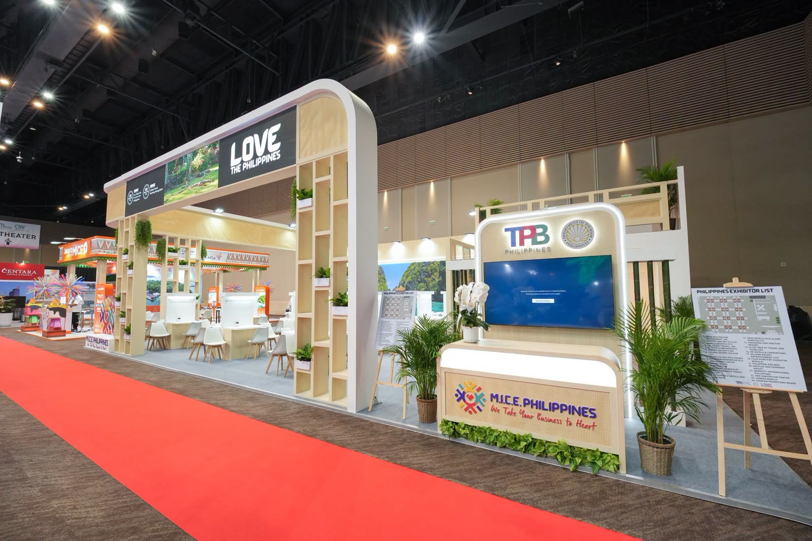 The Philippine pavilion in Bangkok: a TPB Philippines and MICE Philippines counter, a LOVE the Philippines arch and meeting booths along a red carpet