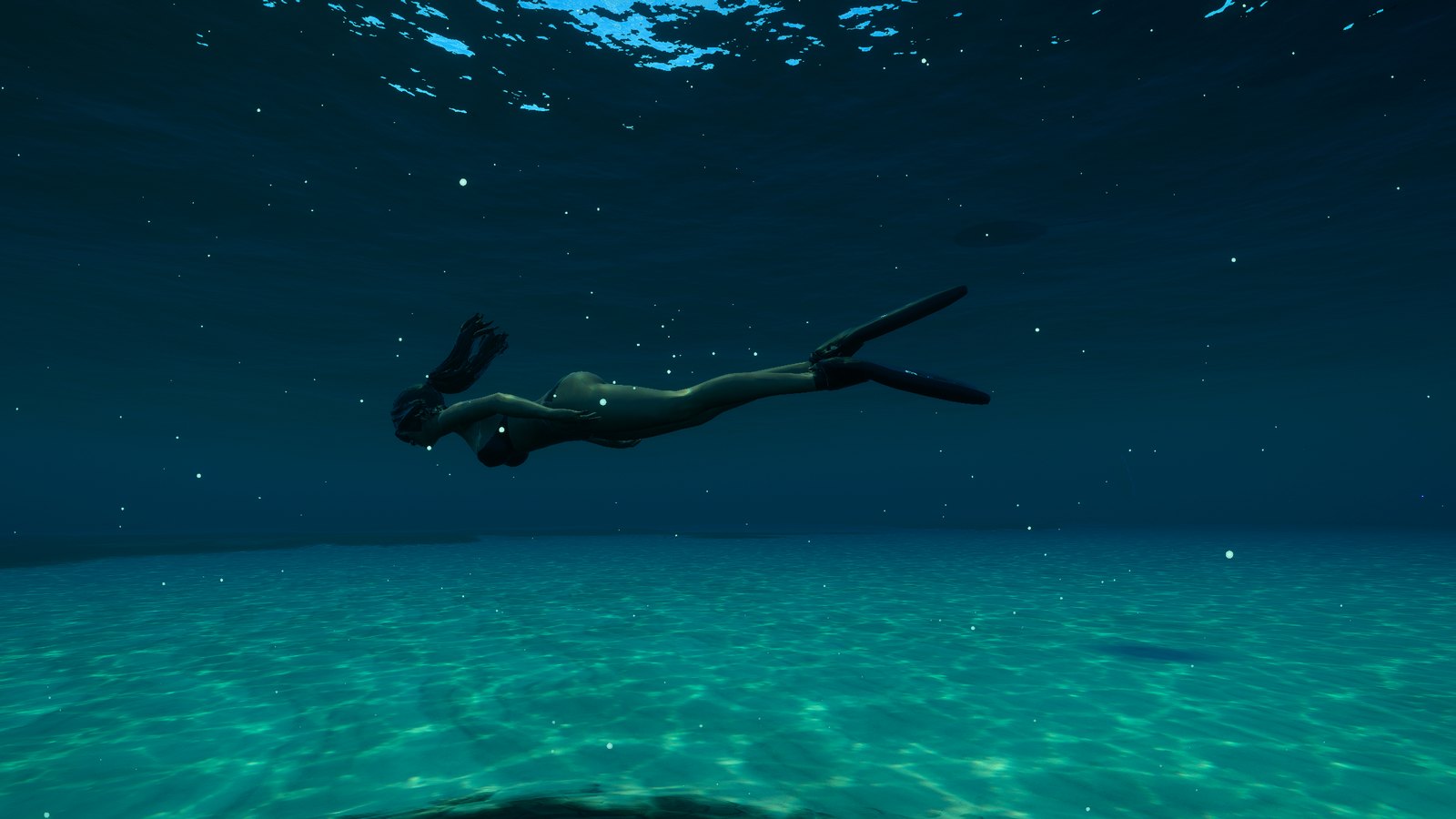 A freediver on long carbon Alchemy fins over the sand