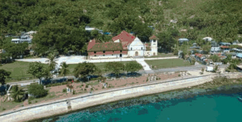 Aerial view of Boljoon Church beside the seawall and turquoise water