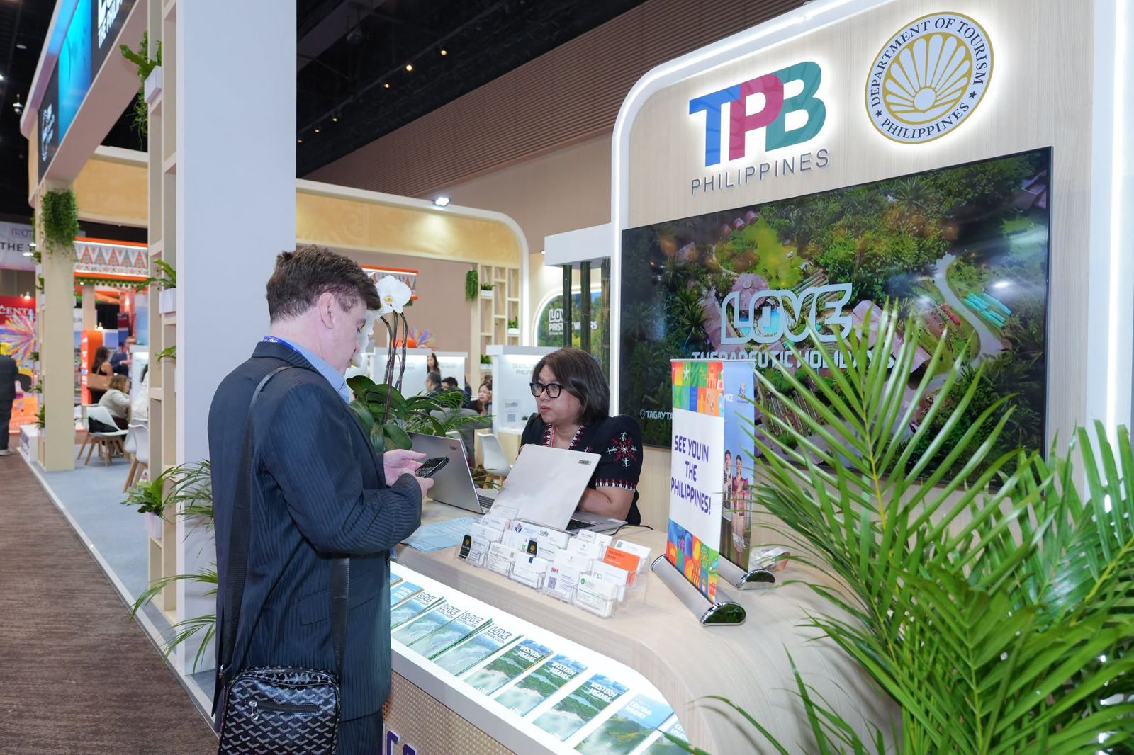 A visitor at the TPB Philippines counter, under the Department of Tourism seal